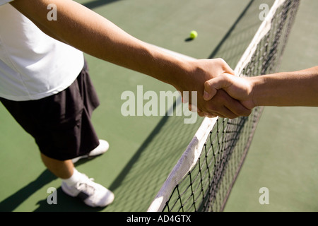 Due giocatori di tennis di agitare le mani in tutta la rete Foto Stock