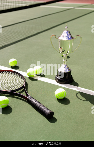 Un trofeo di argento, una racchetta da tennis e le sfere su un campo da tennis Foto Stock