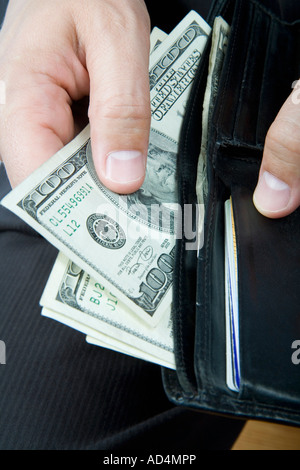 Un imprenditore tenendo US Bank note dal suo portafogli Foto Stock