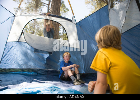 Due giovani ragazzi seduti in una tenda vuota Foto Stock