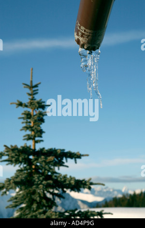 Acqua che scorre da un tubo in un ambiente alpino Foto Stock