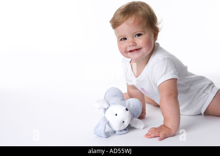 Carino baby ragazza seduta sul pavimento Foto Stock