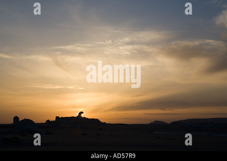 Scultoree forme rock contro le nuvole e sole di setting. Deserto Bianco Farafra, Egitto. Foto Stock