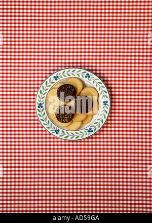 Plate of biscuits on red and white chequered table cloth 1 Foto Stock