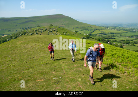 Visite guidate a piedi gruppo la voce di draghi Back in black montagne vicino Pengenffordd Powys Wales UK guardando indietro di Mynydd Troed Foto Stock