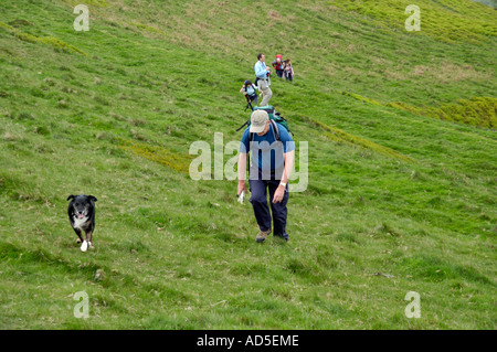 Visita guidata a piedi di gruppo con cane sul sentiero fino ripida collina in Montagna Nera Monmouthshire South Wales UK Foto Stock