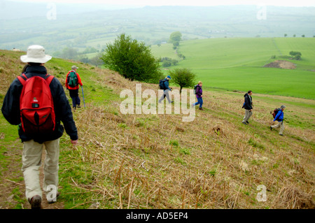 Guidate il gruppo a piedi in discesa sul sentiero dal vertice di Fawr Skirrid Mountain Abergavenny Monmouthshire South Wales UK Foto Stock