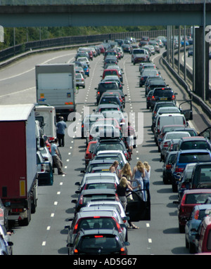 Autostrada chiusa a causa di un incidente con annoiato automobilista intrappolati in una lunga tailback congestione inquinamento persone cambiamento climatico Foto Stock