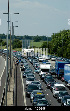 Autostrada chiusa a causa di un incidente con annoiato automobilista intrappolati in una lunga tailback congestione inquinamento persone cambiamento climatico Foto Stock