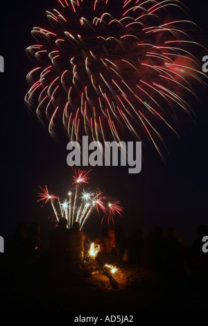 Fuochi d'artificio sulla spiaggia con persone che guardano la holding sprinkers Foto Stock