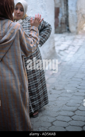 Due donne tenendo una discussione per le strade di Fez, Marocco Foto Stock