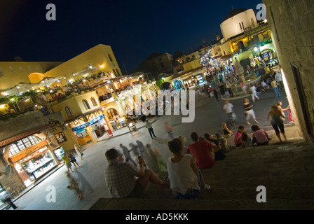 Sopraelevata orizzontale ampio angolo di gente seduta sui gradini nella famosa Piazza Ippokratous a Rodi Città Vecchia di notte. Foto Stock