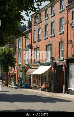 Fila di negozi sotto il sole, old town Llanidloes Powys mid Wales UK Foto Stock