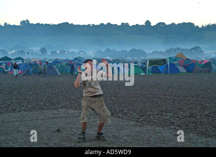 Un giovane raver Glastonbury ballare nel fango nelle prime ore del mattino. Somerset, Regno Unito Foto Stock