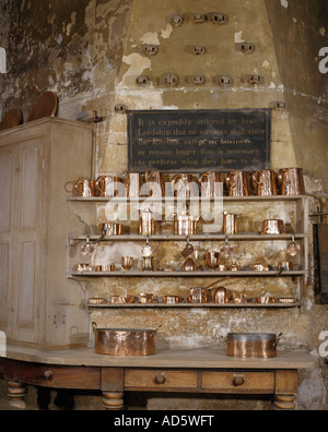 Antiquariato brocche di rame e le attrezzature di cottura su scaffalature di legno nella grande cucina antica Foto Stock