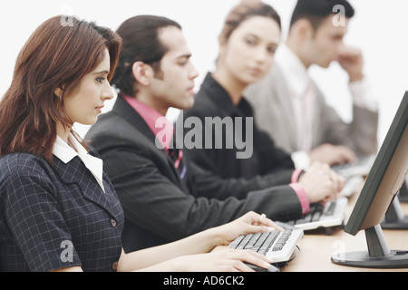Due imprenditori e due imprenditrici seduti davanti a un computer Foto Stock