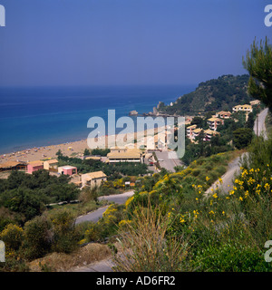 Sandy Bay e case sul pendio boschivo tra fiori ed erbe Glifada Beach Corfu le isole greche - Grecia Foto Stock