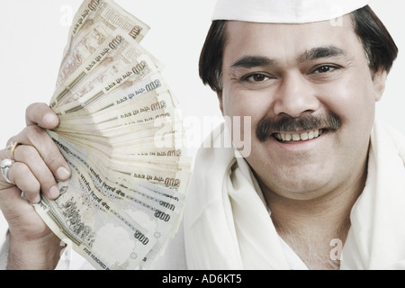Ritratto di un uomo maturo tenendo la valuta indiana Foto Stock