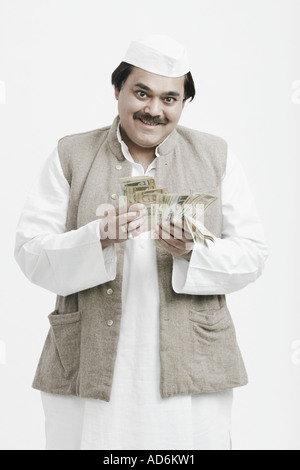 Ritratto di un uomo politico contando la valuta indiana Foto Stock