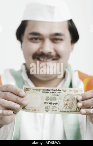 Ritratto di un uomo maturo tenendo la valuta indiana Foto Stock