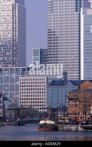 Torri di uffici di Canary Wharf si affaccia appartamenti moderni e chiatta olandese a Millwall Docks, Docklands di Londra, Inghilterra Foto Stock
