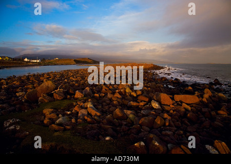 Spiaggia rocciosa su Atlantic Drive rosso incandescente nella luce della sera, vicino Mulrany, County Mayo, Irlanda Foto Stock
