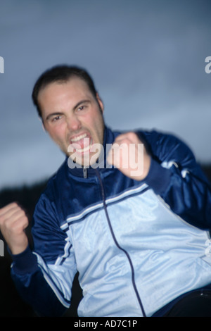 Giovane uomo in un sudore suit jacket il tifo di fronte nuvole scure Foto Stock