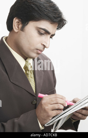 Close-up di un imprenditore iscritto su un giornale Foto Stock