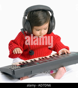 Close-up di un bimbo che indossano le cuffie la riproduzione di un pianoforte elettronico Foto Stock