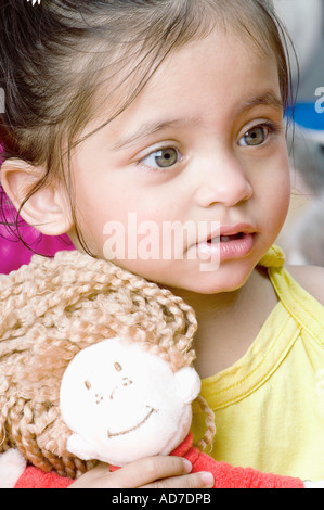 Close-up di una bambina tenendo una bambola Foto Stock