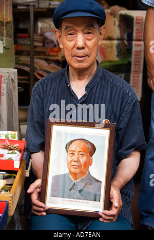 Uomo di vendita memorabilia di Mao al mercato di Panjiayuan noto anche come mercato di sporco a Pechino 2007 Foto Stock