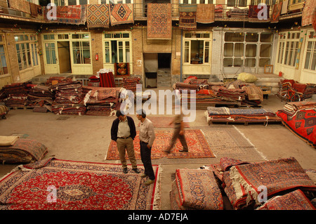 Un venditore e compratore parlando del prezzo di un tappeto in un negozio di tappeti nel bazaar di Tehran. Foto Stock