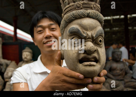 Uomo con legno scolpito a testa Panjiayuan mercatino di antiquariato noto anche come mercato di sporco a Pechino 2007 Foto Stock