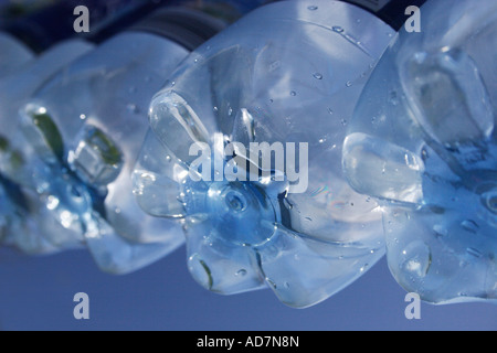 Vista parte inferiore della molla in plastica bottiglie di acqua appesa sulla linea Foto Stock