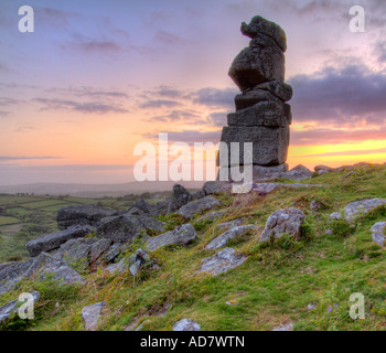 Bowermans Naso di roccia di granito formazione vicino Hayne giù sul Dartmoor con il sorgere del sole direttamente dietro Foto Stock