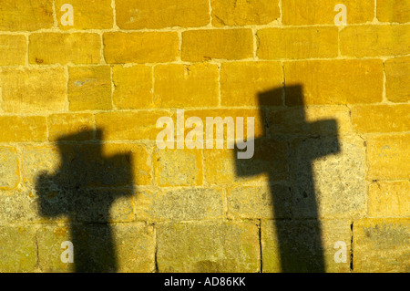 Le ombre di due croci sul cimitero Foto Stock