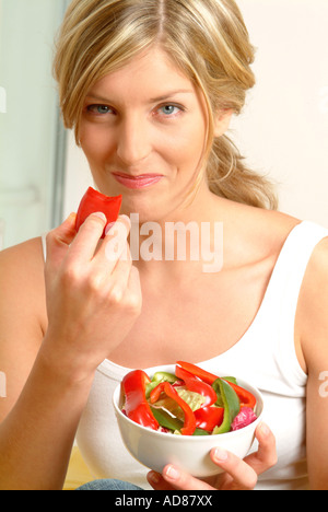 Ritratto di donna di mangiare il pepe rosso Foto Stock