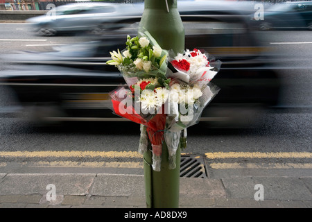 Un omaggio floreale fissato ad una lampada posta sulla scena di un incidente stradale in Birmingham Foto Stock