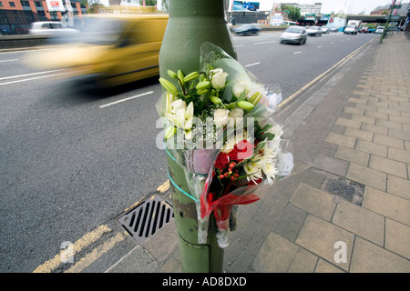 Un omaggio floreale fissato ad una lampada posta sulla scena di un incidente stradale in Birmingham Foto Stock