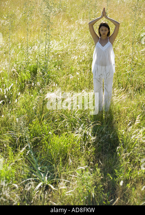 Donna fare yoga pone nel campo Foto Stock