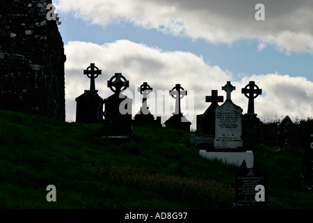 Stagliano celtic cross marcatori grave contro un striped cielo luminoso Burrishoole Abbey Paese Mayo Irlanda Foto Stock