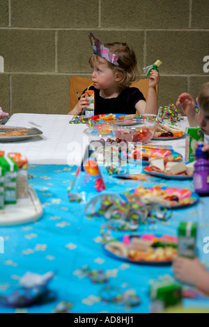 Festa di compleanno per bambini adorabile assorbita assicurato e multirazziale in background multi razziale persone compleanno torta di compleanno festa di compleanno Foto Stock