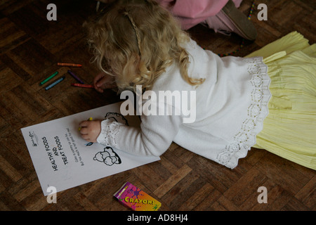 Festa di compleanno per bambini adorabile assorbita assicurato e multirazziale in background multi razziale persone compleanno torta di compleanno festa di compleanno Foto Stock