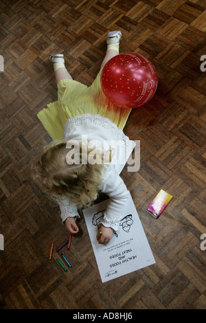 Festa di compleanno per bambini adorabile assorbita assicurato e multirazziale in background multi razziale persone compleanno torta di compleanno festa di compleanno Foto Stock