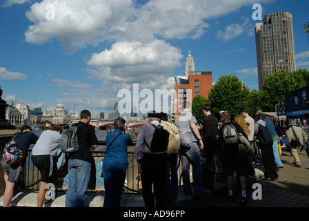 Ai visitatori di ammirare vista della città di Londra da Queen's Walk South Bank di Londra Inghilterra Foto Stock