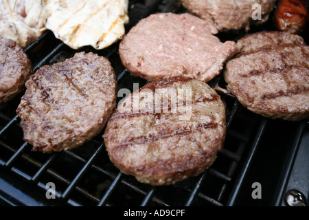 Vari tipi di carne cotti su un gas powered barbecue. Foto Stock