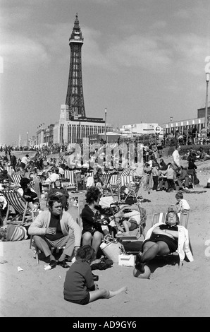 Blackpool Lancashire Regno Unito circa agosto 1975. La Blackpool Tower è un famoso punto di riferimento e il sole estivo: Le famiglie si riuniscono sulla spiaggia. 1970S UK HOMER SYKES Foto Stock