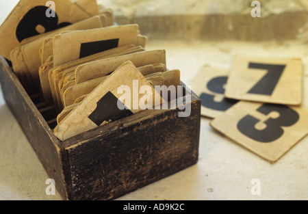 Vecchia scatola di legno seduto su una profonda davanzale e contenente ben indossati carte con numeri individuali per inno display Foto Stock