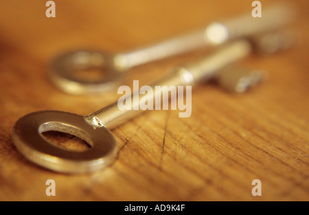 Due d'argento doorkeys giacente su di un tavolo di legno o su una scrivania o a bordo in serata calda luce Foto Stock