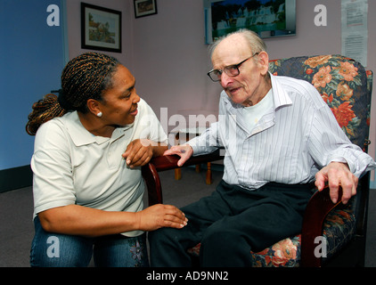 Membro del personale di cura interagire con uomo anziano presso la casa di cura per le persone affette da demenza, Londra, Regno Unito. Foto Stock